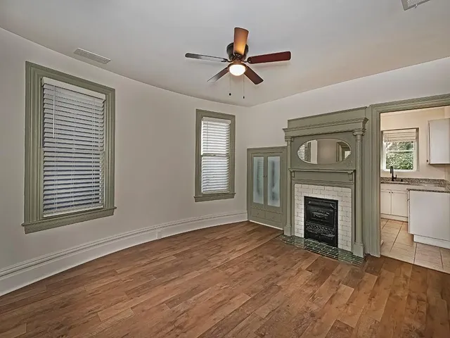 a view of an empty room with a fireplace and a window