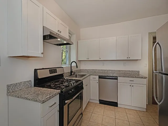 a kitchen with stainless steel appliances granite countertop a stove a sink and a refrigerator