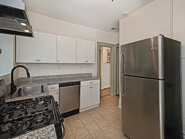 a kitchen with stainless steel appliances granite countertop a refrigerator sink and stove