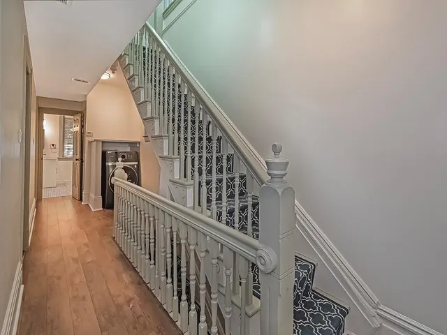 a view of a hallway with wooden floor and staircase