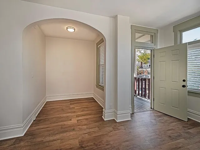 an empty room with wooden floor and a window