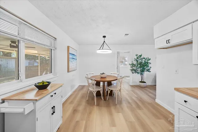 a dining room with furniture potted plants and wooden floor
