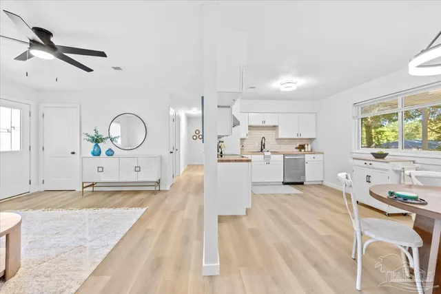 a view of a kitchen with kitchen island a counter top space a sink stainless steel appliances and cabinets