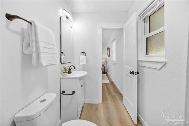 a bathroom with a sink a toilet a mirror and shower