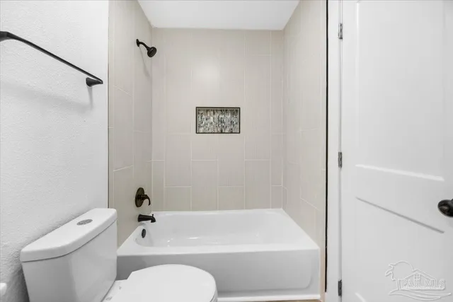 a white toilet sitting next to a bath tub