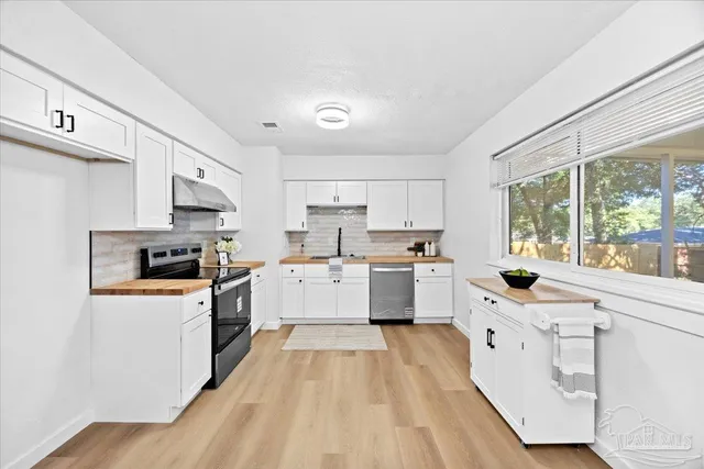 a large kitchen with white cabinets and white appliances