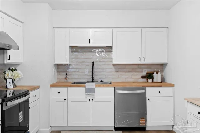 a kitchen with stainless steel appliances white cabinets and a sink