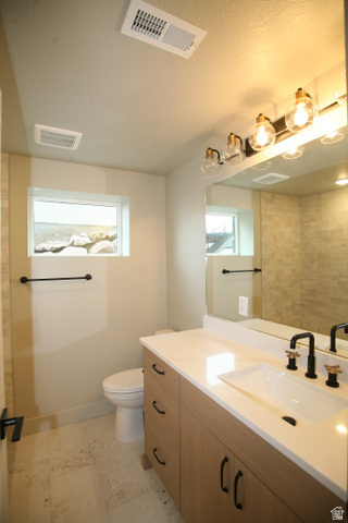 635 East Mountain Road North Ogden, UT 84414 - Photo 22 of 33 Bathroom featuring a wood-finish vanity with a light-colored countertop, an undermount sink, and a black faucet with gold accents