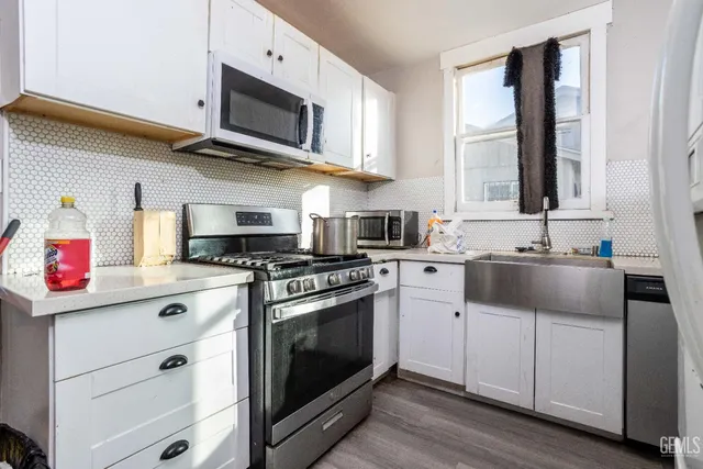 a kitchen with stainless steel appliances granite countertop a sink a stove and cabinets