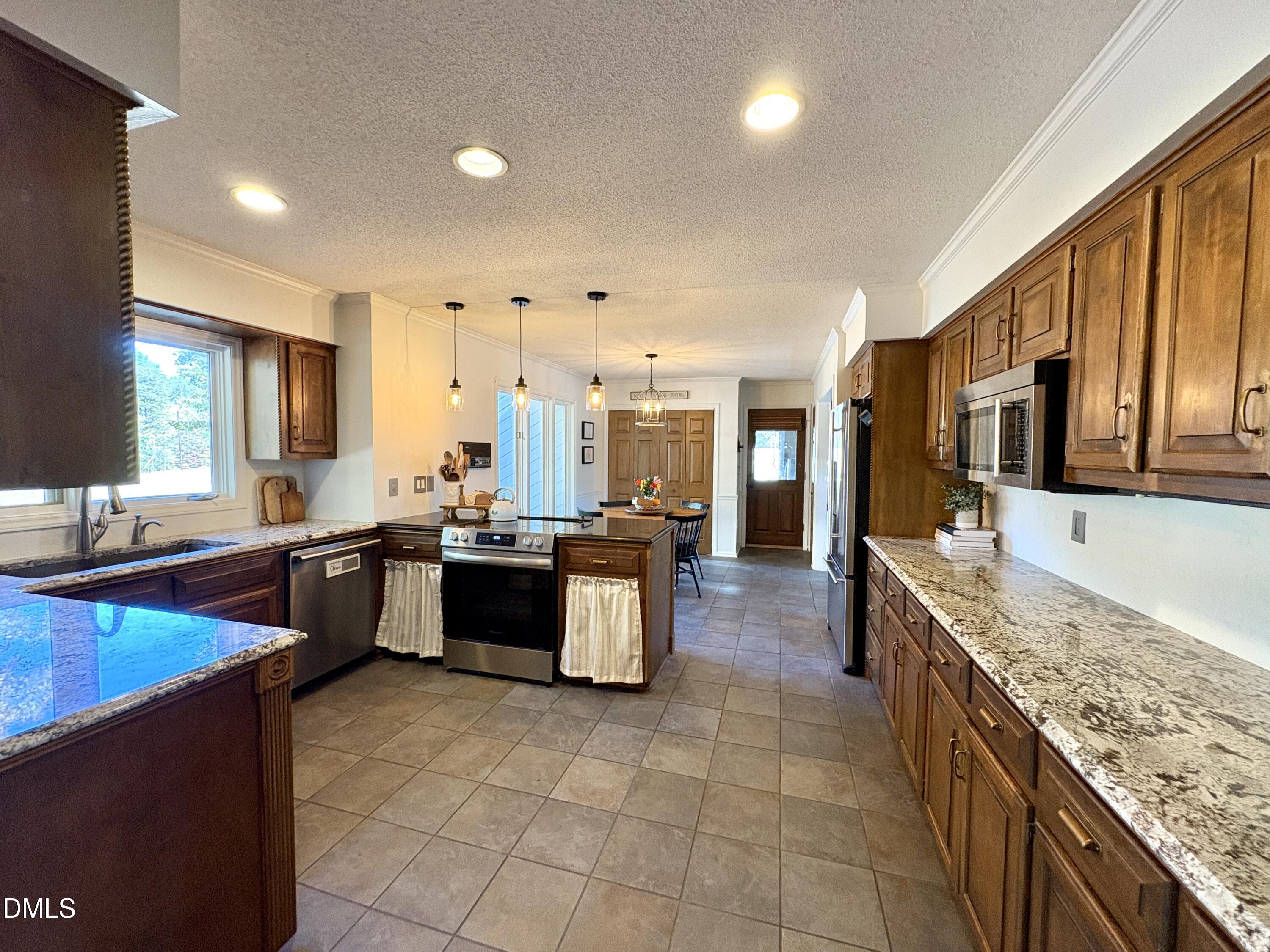 625 McCray Road Burlington, NC 27217 - Photo 10 of 38 a large kitchen with granite countertop a large counter top and stainless steel appliances