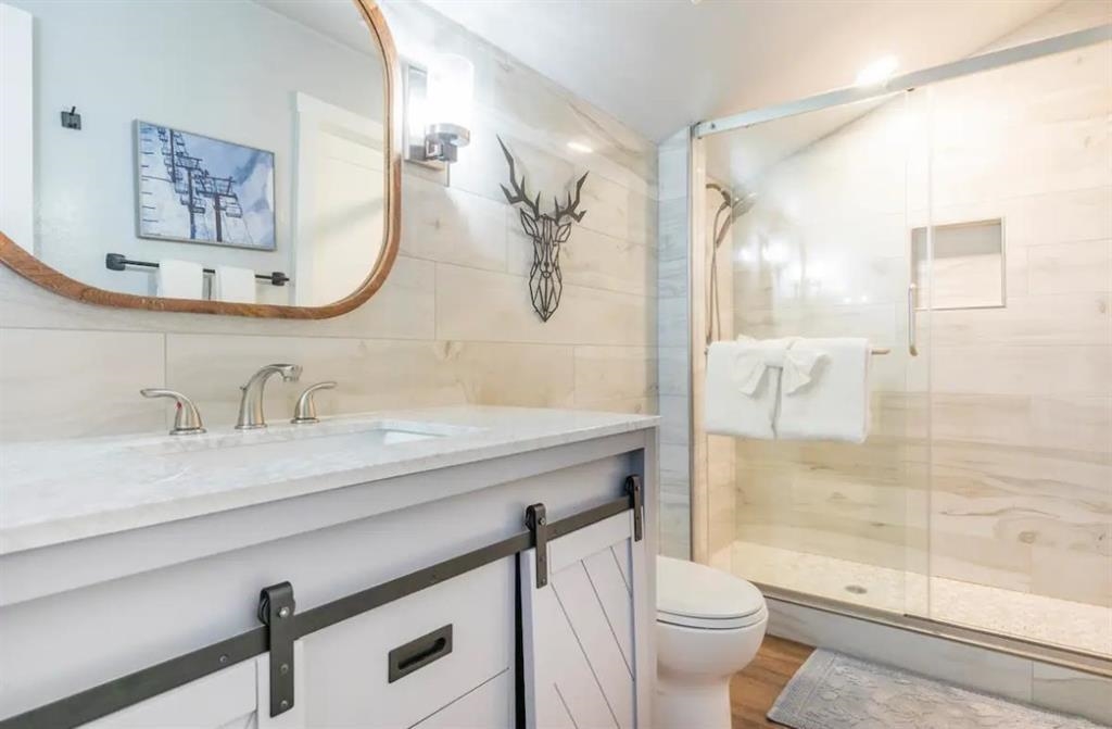 137 Laurel Mountain Road, Unit 418 Mammoth Lakes, CA 93546 - Photo 10 of 23 Full bath featuring vanity, a stall shower, tile walls, and light wood-type flooring