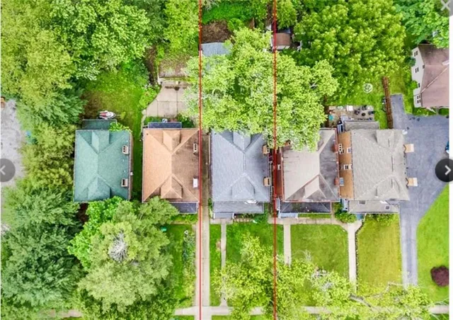 an aerial view of residential house with outdoor space and trees all around