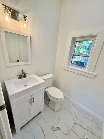 a spacious bathroom with a toilet sink and mirror
