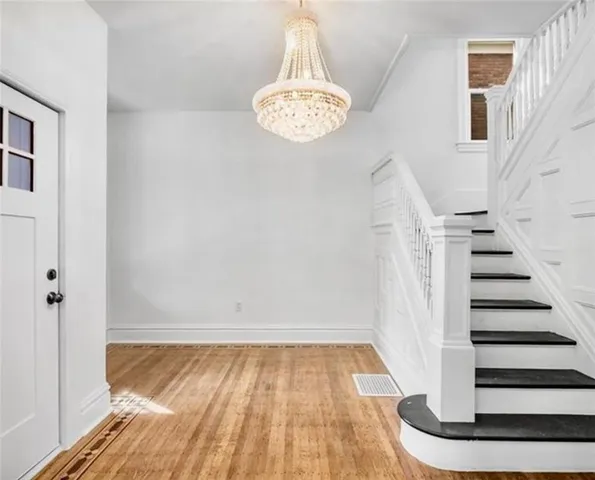 a view of a room with wooden floor and white walls