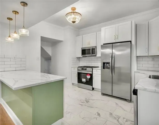 a kitchen with kitchen island a counter top space and stainless steel appliances