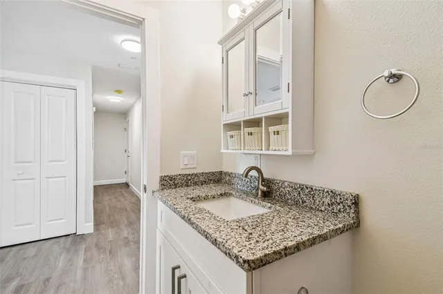 a bathroom with a granite countertop sink and a mirror