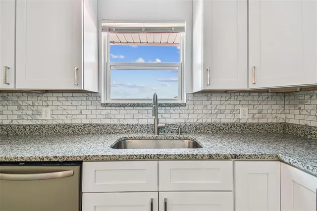 a kitchen with granite countertop a sink and cabinets