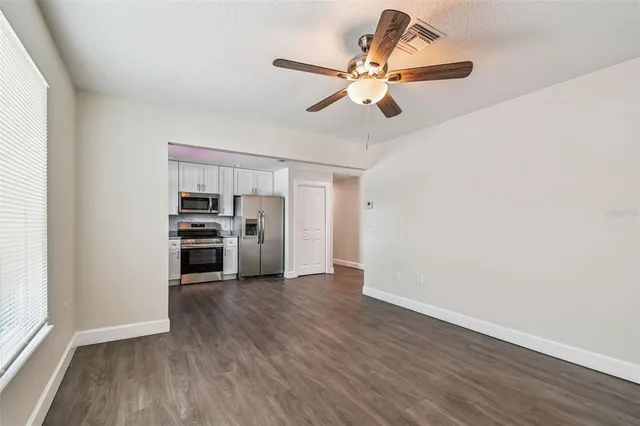 a view of a kitchen with a sink cabinet a ceiling fan and wooden floor