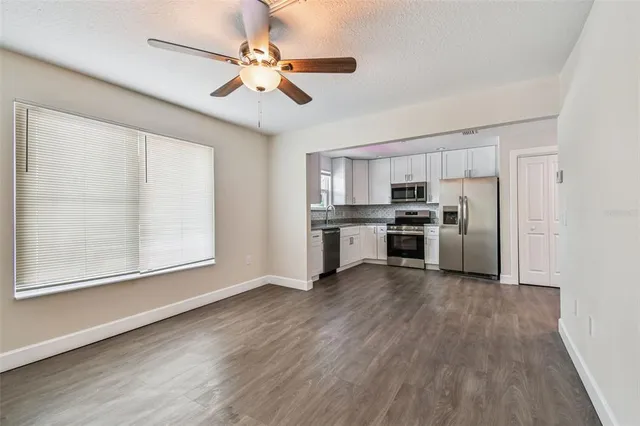 a view of kitchen with sink microwave refrigerator and cabinets