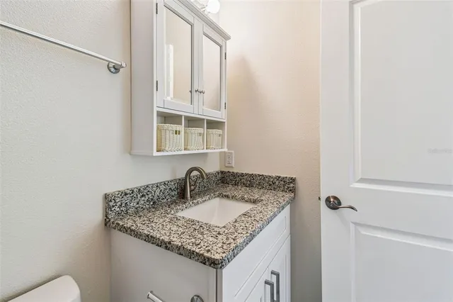 a bathroom with a granite countertop sink and a mirror