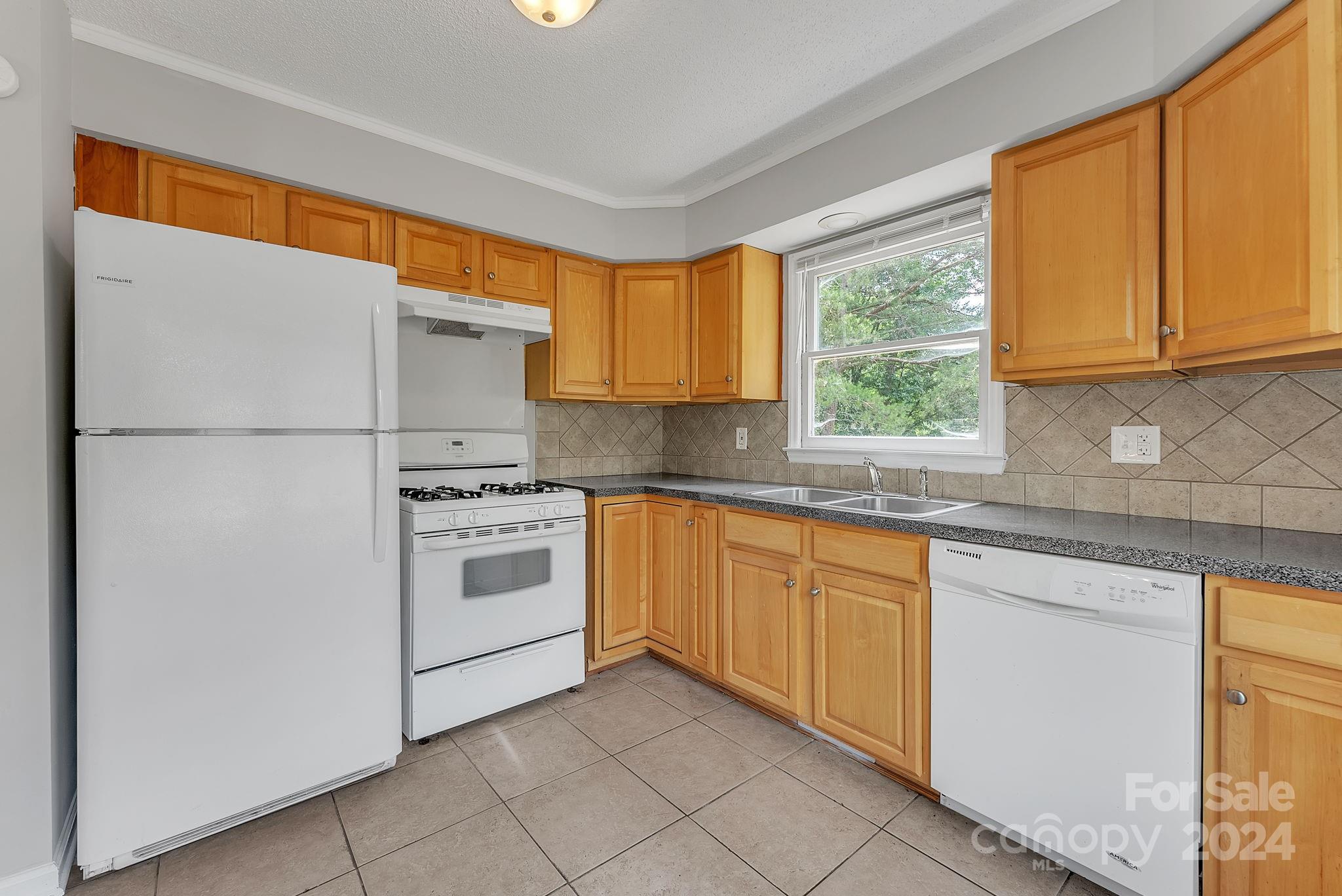 1018 Palmyra Drive Tega Cay, SC 29708 - Photo 21 of 36 a kitchen with a white cabinets and a stove top oven