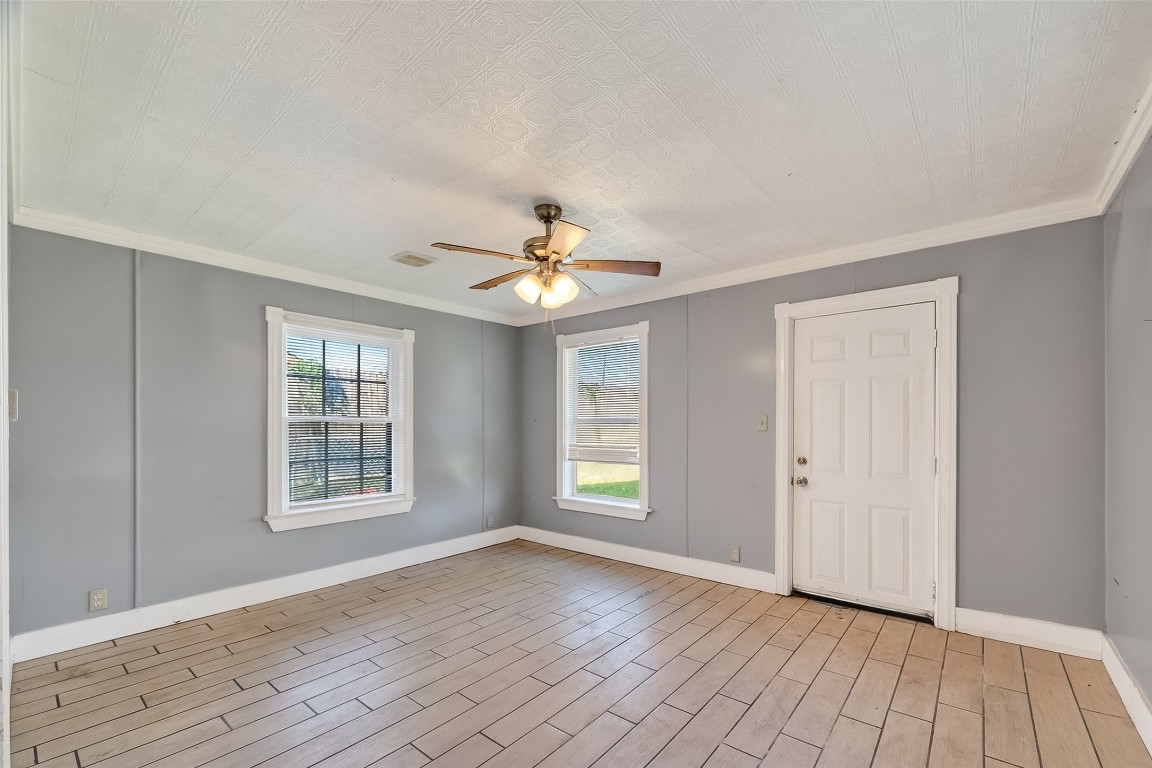 15627 Market Street Channelview, TX 77530 - Photo 11 of 35 an empty room with wooden floor chandelier fan and windows