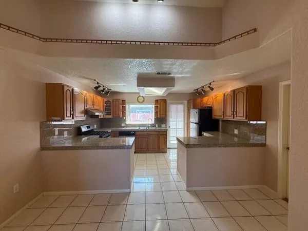 a kitchen with a sink a counter top space cabinets and stainless steel appliances