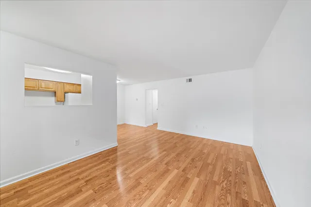 a view of empty room with wooden floor