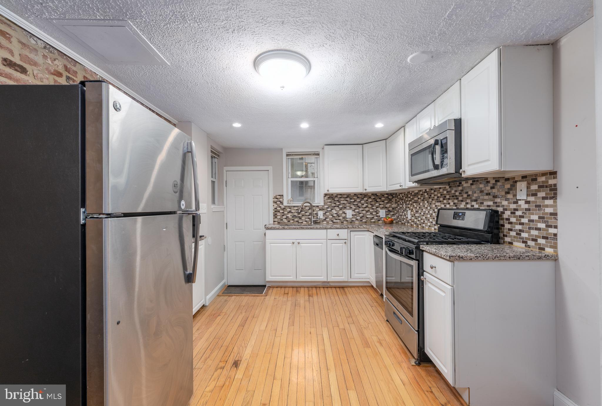 1627 Olive Street Baltimore, MD 21230 - Photo 8 of 22 a kitchen with stainless steel appliances granite countertop a refrigerator a stove and a sink