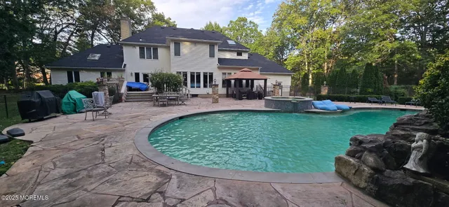 a view of a house with backyard sitting area and swimming pool