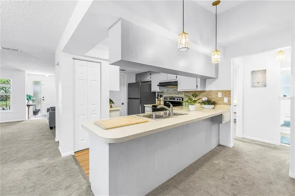 a view of an empty room with a window and swing chair
