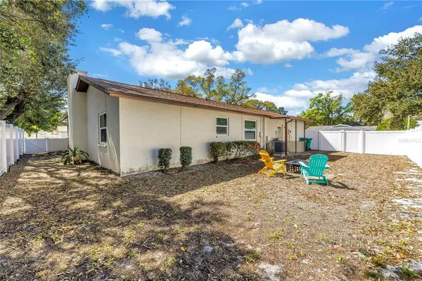 a view of backyard with swimming pool and seating space