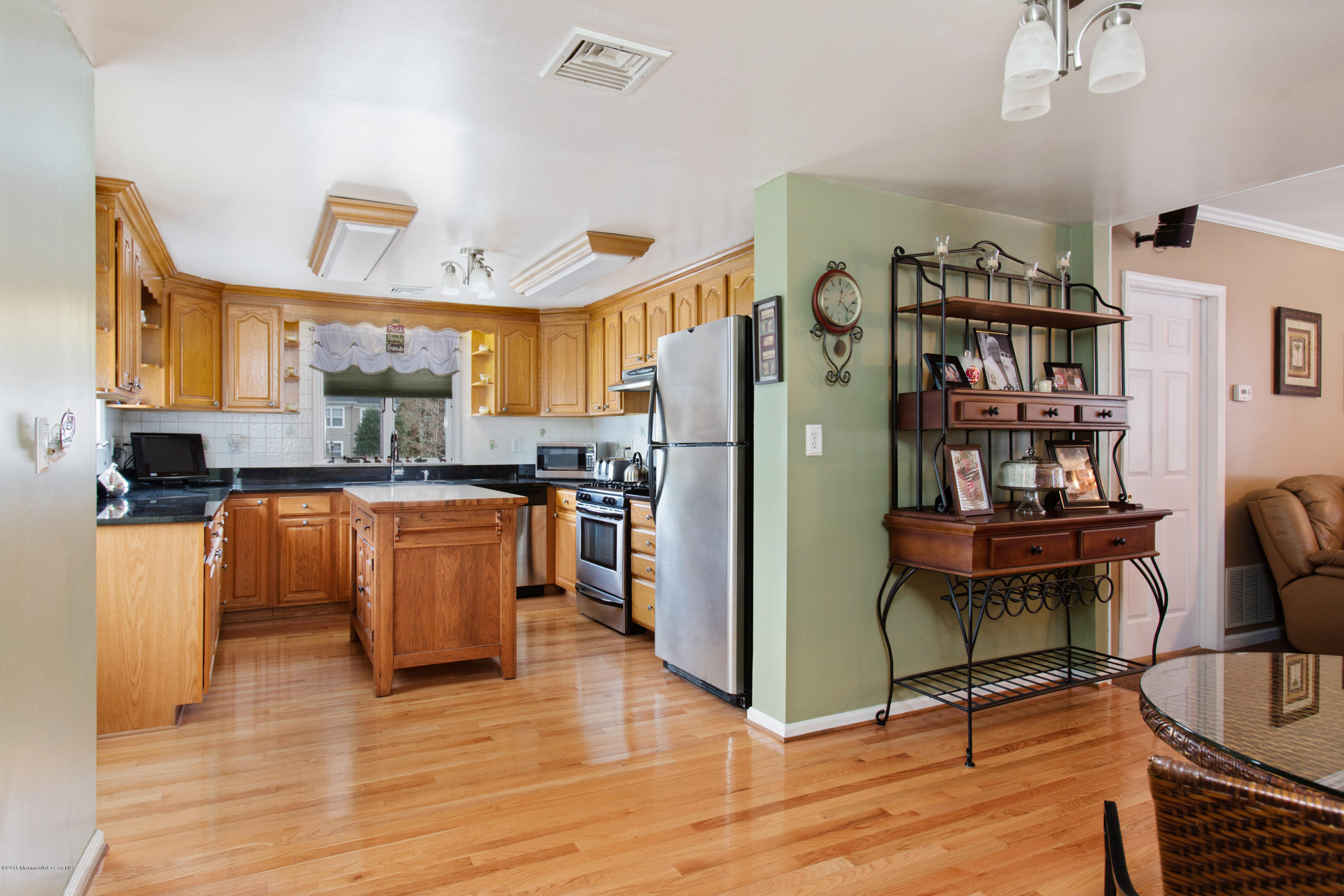 312 Florence Road Middletown, NJ 07748 - Photo 4 of 18 a kitchen with stainless steel appliances granite countertop a refrigerator a stove a sink dishwasher and wooden cabinets with wooden floor