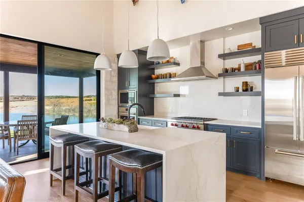 a kitchen with stainless steel appliances granite countertop a sink and a refrigerator