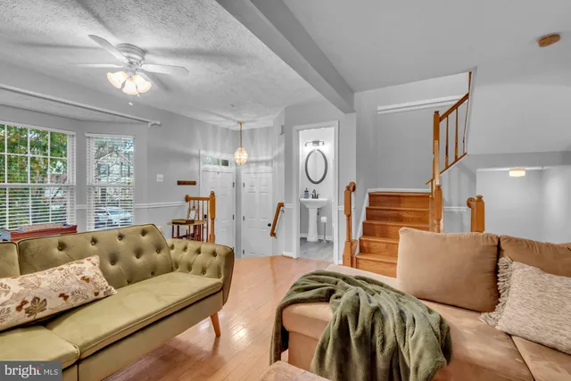 a kitchen with stainless steel appliances granite countertop a refrigerator a sink dishwasher a stove and white cabinets with wooden floor