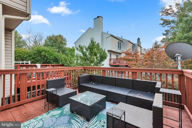 a kitchen with kitchen island granite countertop stainless steel appliances cabinets a sink and a wooden floor