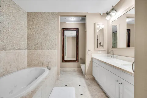 a bathroom with a tub a sink and mirror