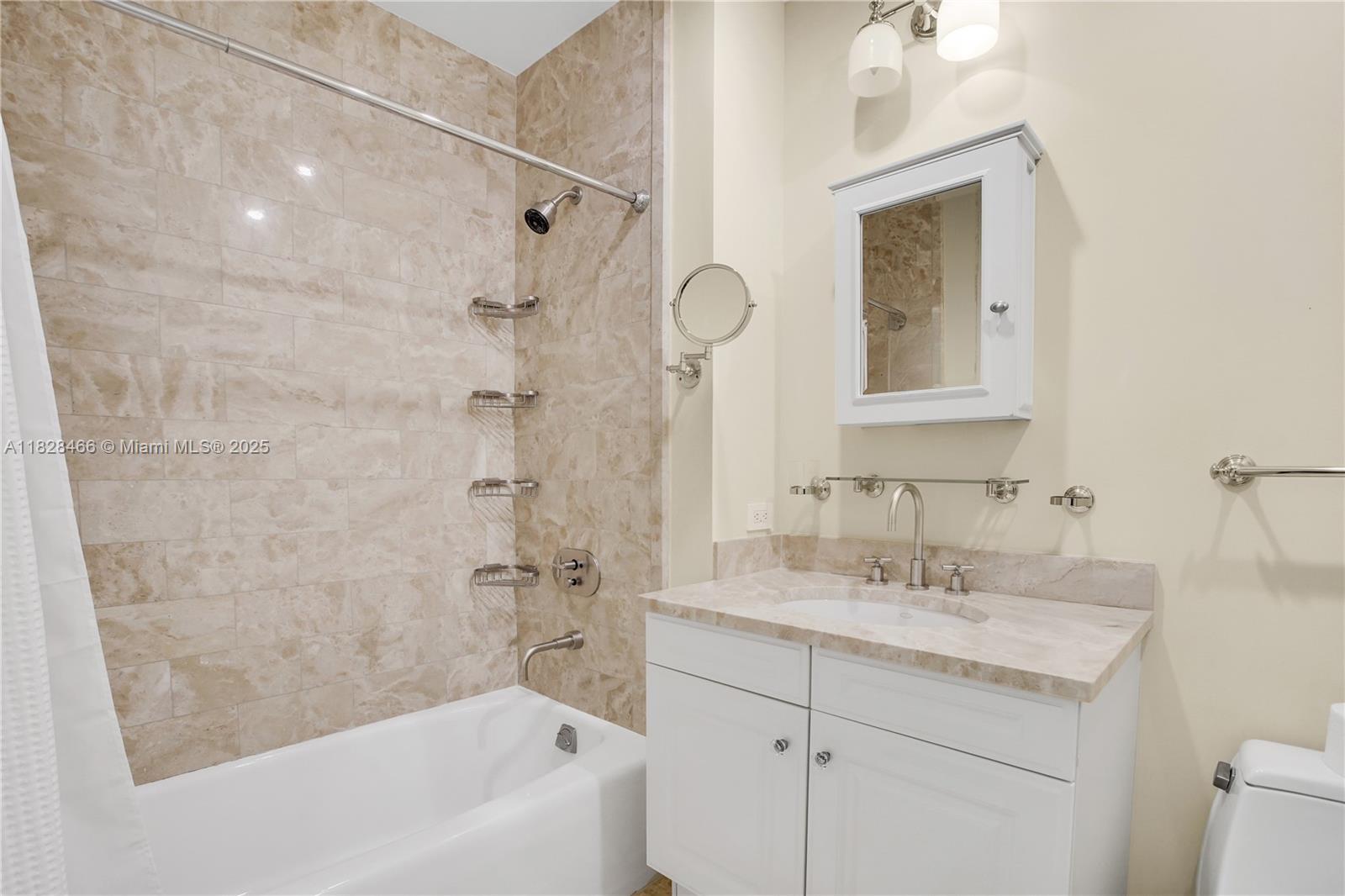 1425 Brickell Avenue, Unit 44AB Miami, FL 33131 - Photo 9 of 19 a bathroom with a sink a mirror and a bathtub