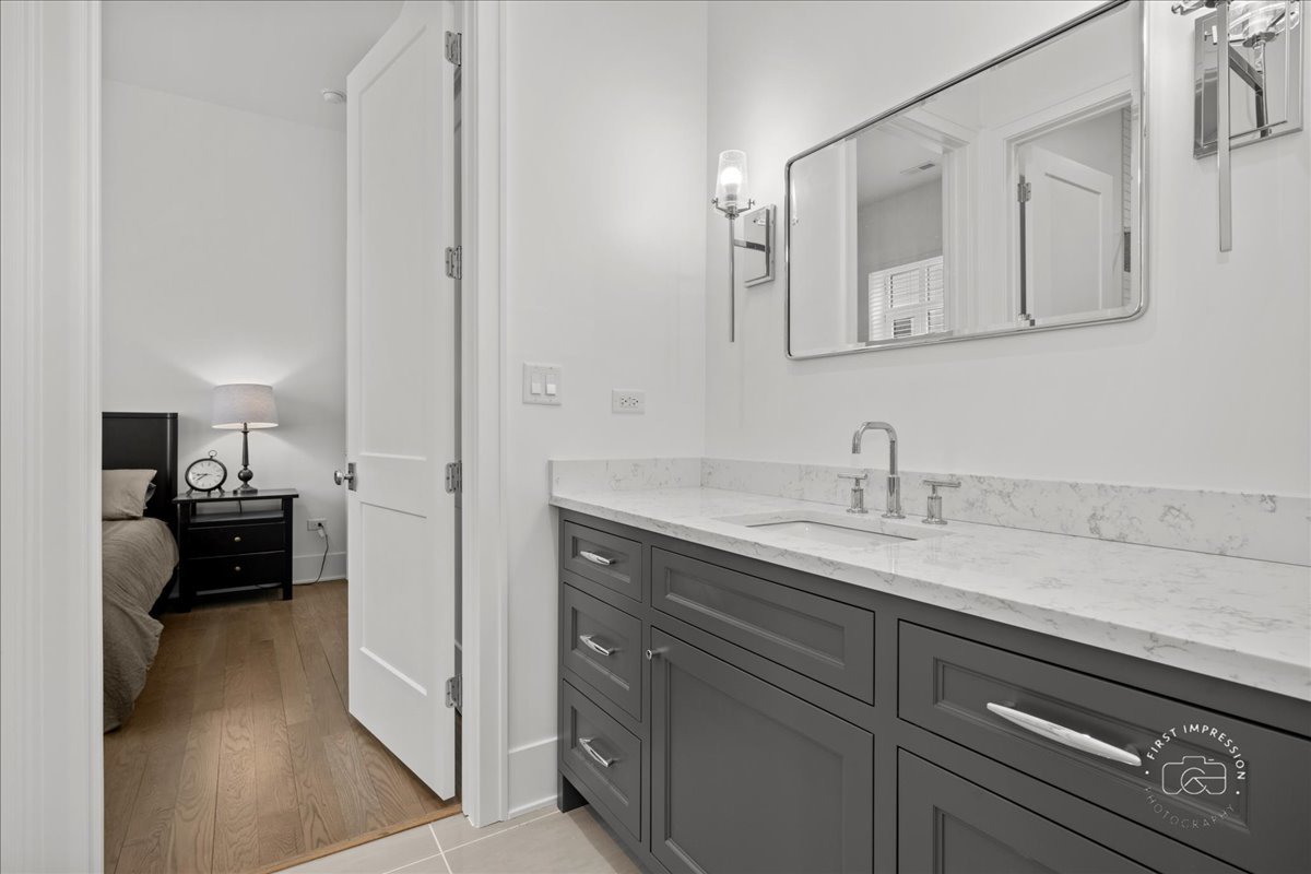 195 North Addison Avenue, Unit PH03 Elmhurst, IL 60126 - Photo 15 of 36 a en suite bathroom with a sink a mirror and a vanity