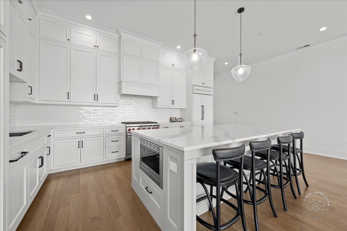 195 North Addison Avenue, Unit PH03 Elmhurst, IL 60126 - Photo 4 of 36 a kitchen with white cabinets stainless steel appliances and a dining table
