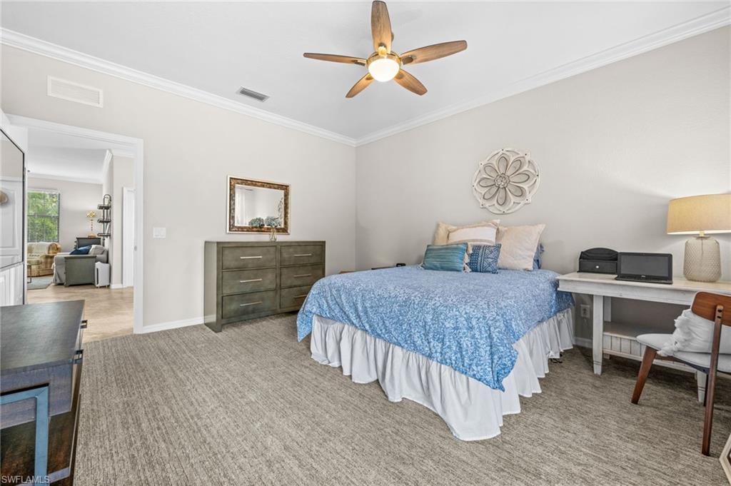 4754 Abaca Circle Naples, FL 34119 - Photo 32 of 46 a bedroom with a bed and a chandelier