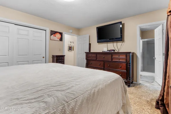 a bedroom with a bed and a flat screen tv