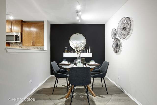 72 Aster Drive, Unit 2024 Schaumburg, IL 60173 - Photo 10 of 31 a dining room with furniture and a mirror