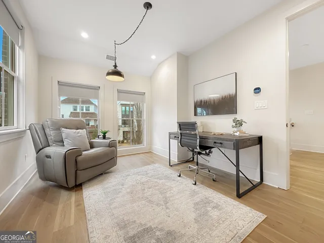 a living room with furniture a window and a flat screen tv