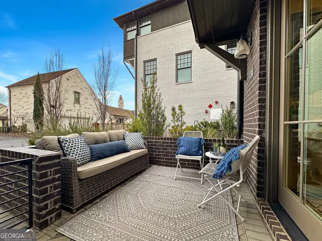 a view of a patio with couches table and chairs and potted plants