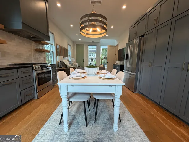 a view of a dining room with furniture a chandelier and wooden floor