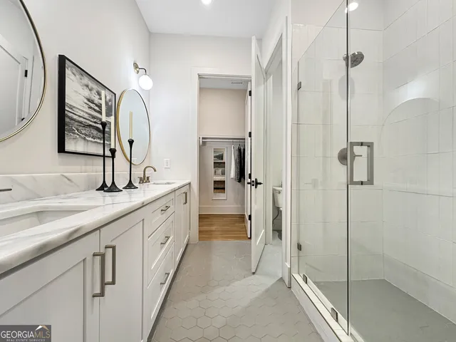 a bathroom with double vanity and a shower