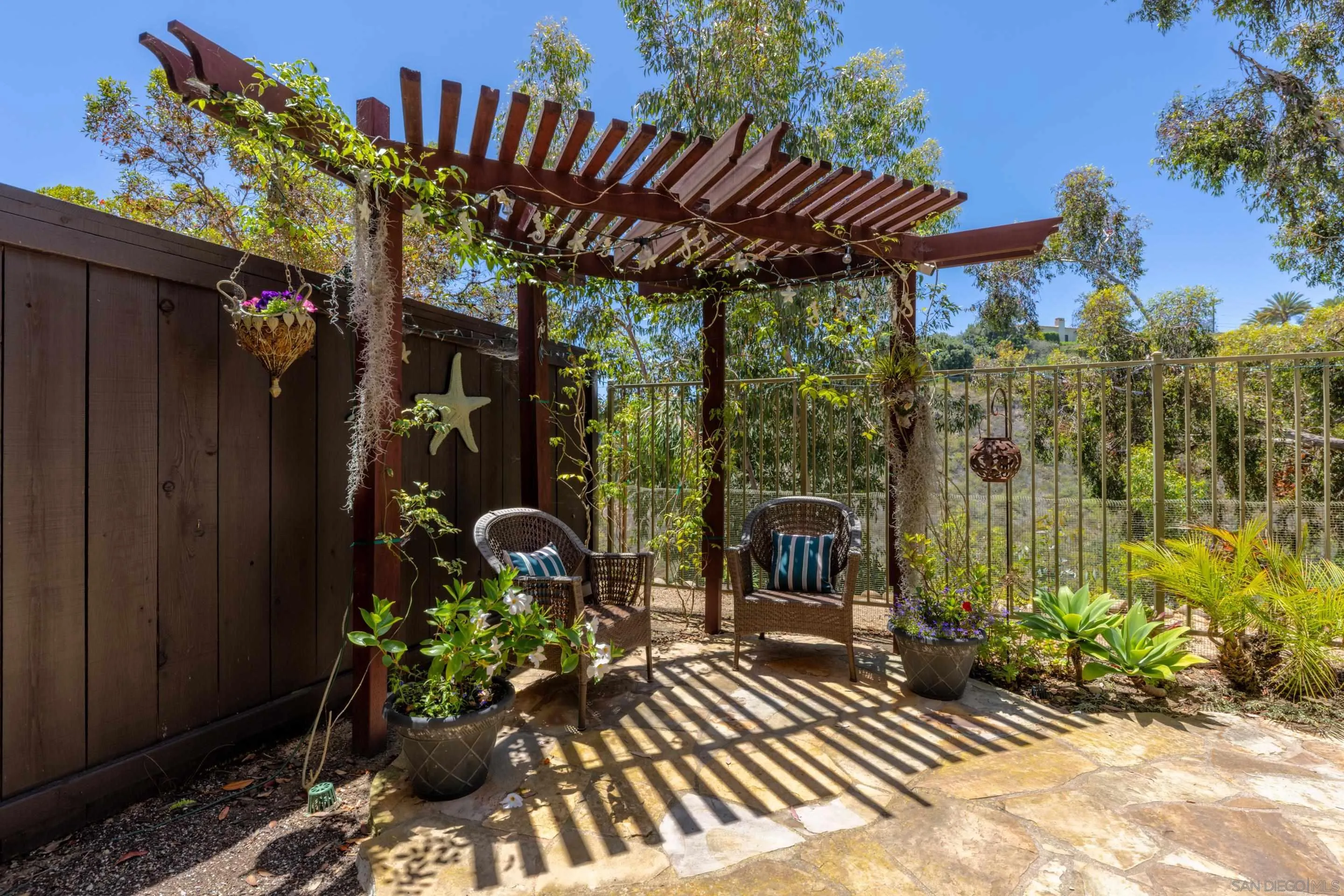 1466 Caminito Solidago La Jolla, CA 92037 - Photo 14 of 62 a view of a patio with table and chairs potted plants with wooden floor and fence