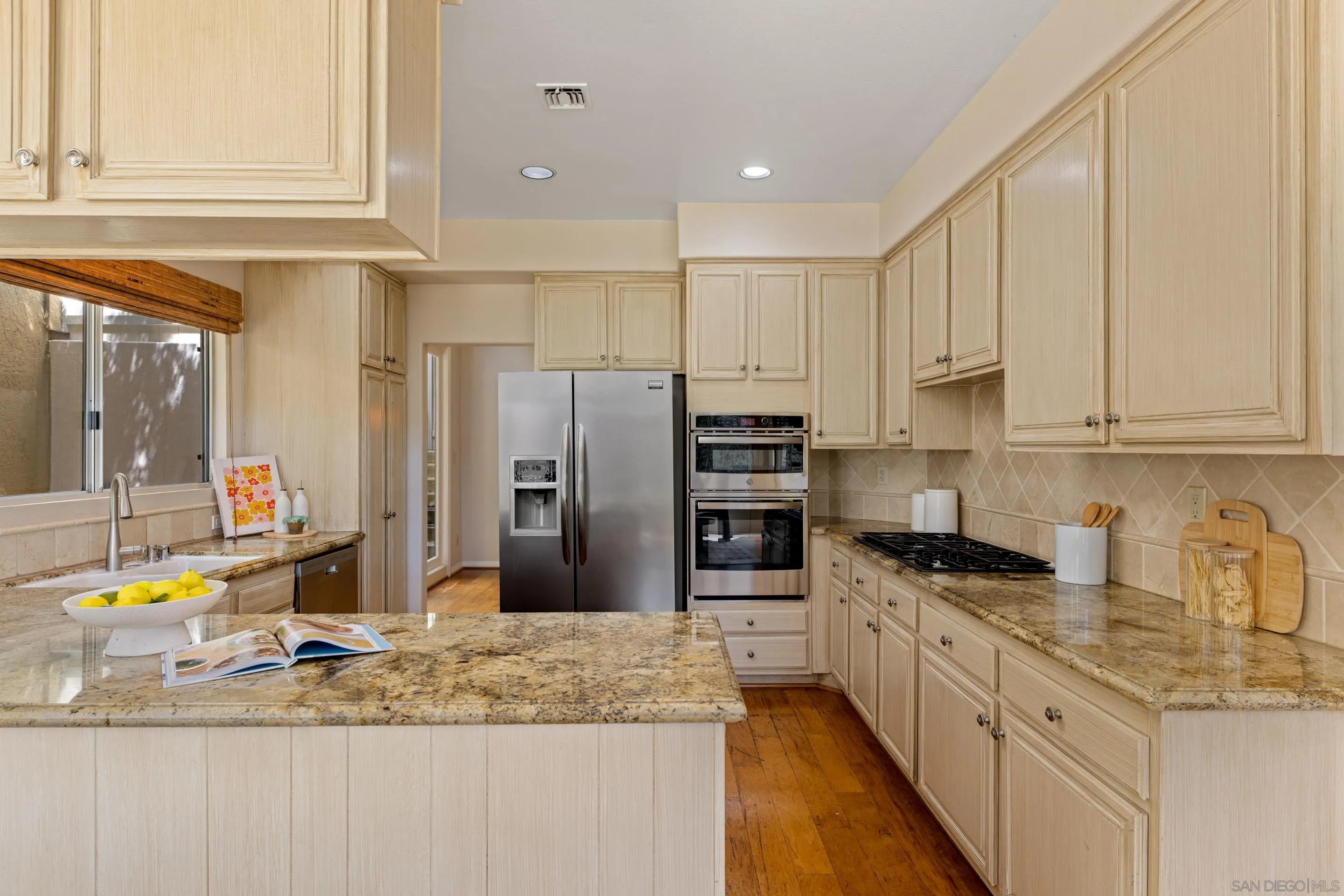 1466 Caminito Solidago La Jolla, CA 92037 - Photo 10 of 62 a kitchen with stainless steel appliances granite countertop a sink refrigerator and cabinets