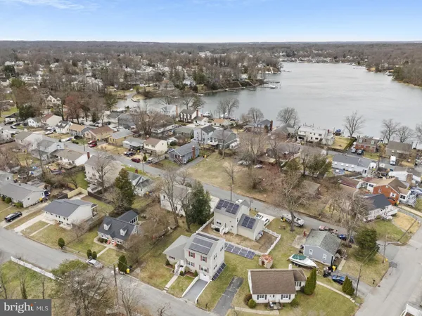 a view of residential houses with yard and lake view